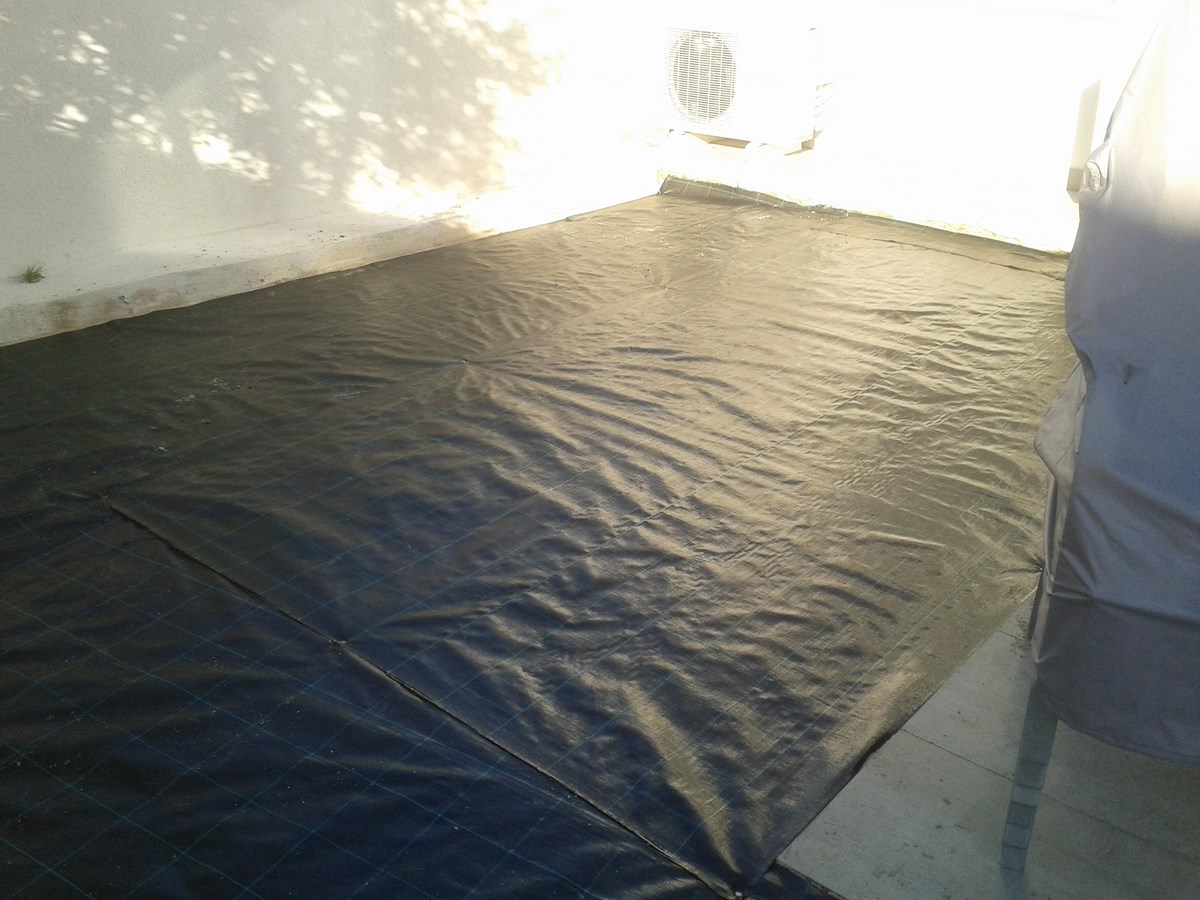 Mise en place d'une toile de paillage lors de la pose d'un gazon synthétique à Marseille